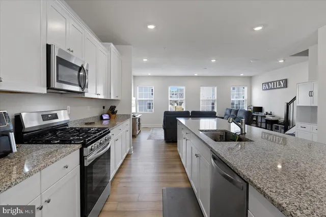 a large kitchen with stainless steel appliances granite countertop a lot of counter space