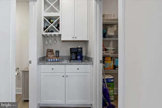 a kitchen with white cabinets and black appliances