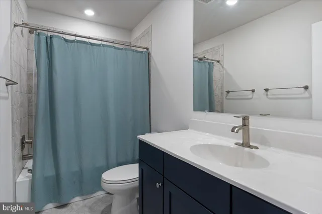 a bathroom with a sink a toilet a mirror and shower curtain