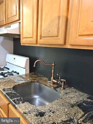 a kitchen with a sink and a stove top oven