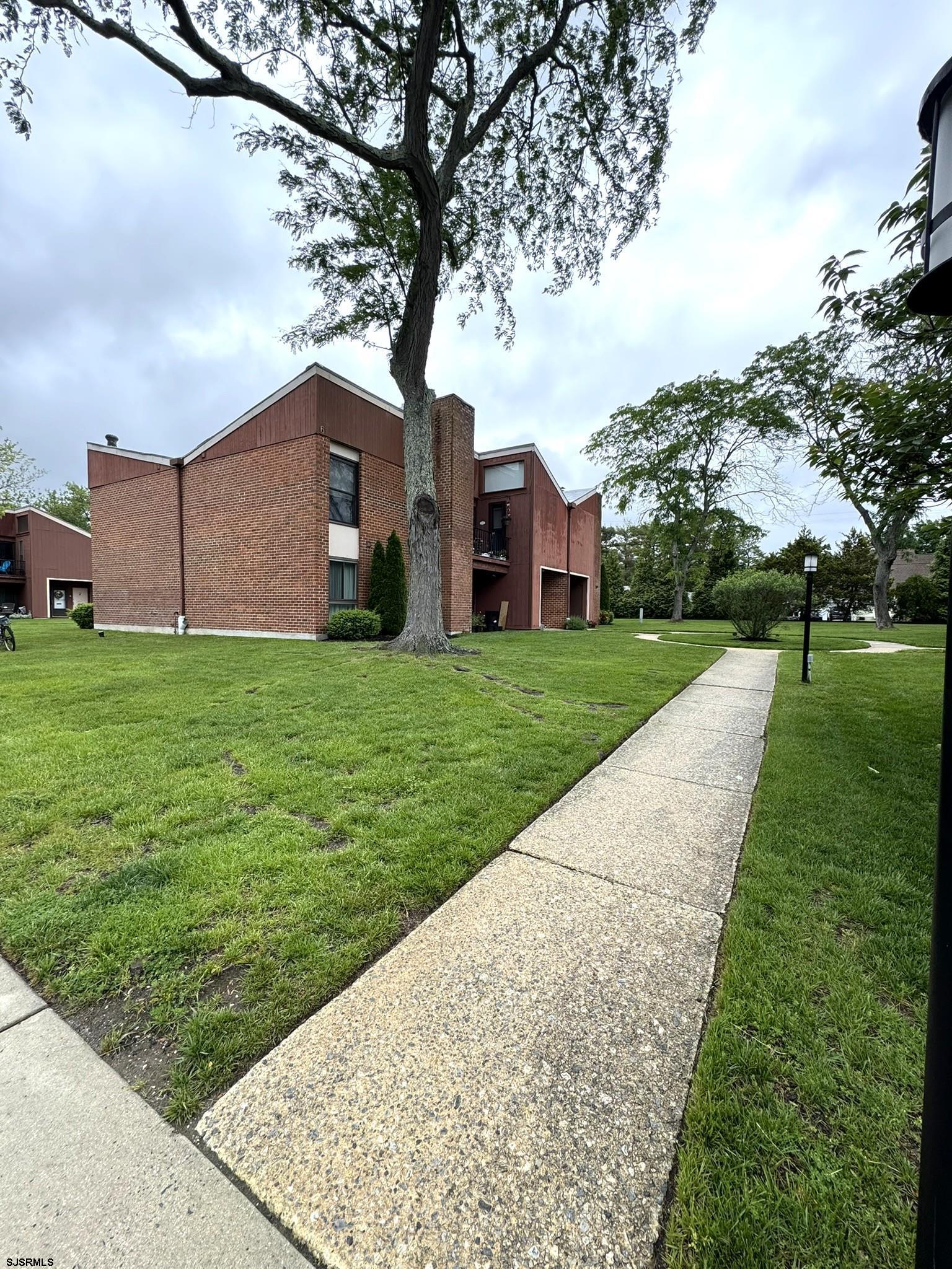 11 Shore Road, Unit 6C Somers Point, NJ 08244 - Photo 2 of 7 a big house with a big yard and large trees