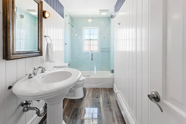 a bathroom with a sink a toilet and shower