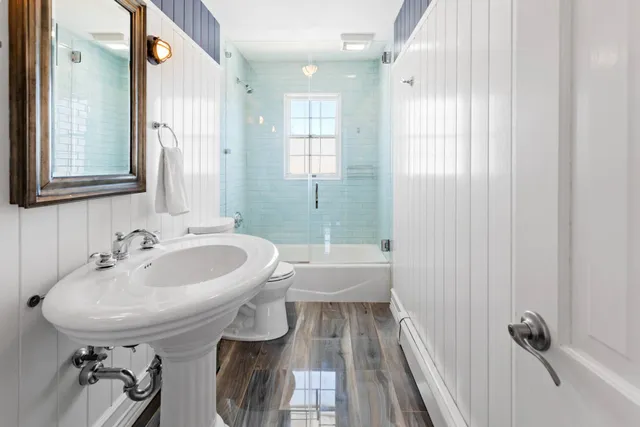 a bathroom with a sink a toilet and shower