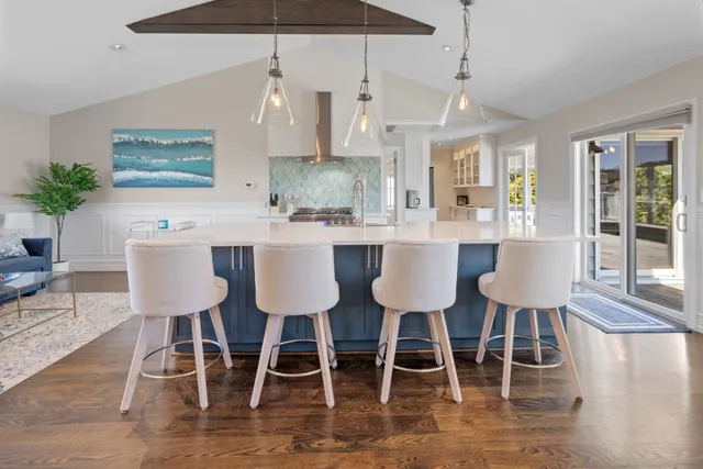 a kitchen with stainless steel appliances a dining table chairs and white cabinets