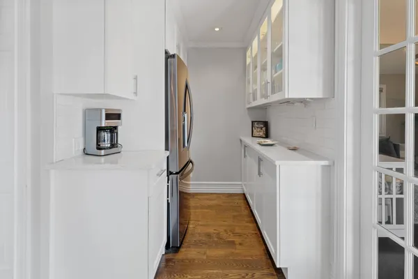 a kitchen with a refrigerator a stove top oven and white cabinets