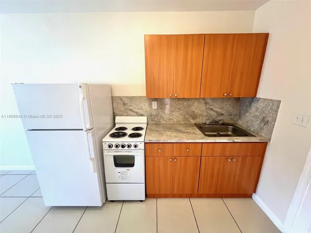 a kitchen with a stove a refrigerator and a sink