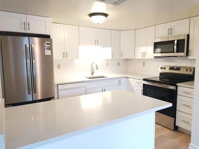 a kitchen with stainless steel appliances a refrigerator sink and microwave