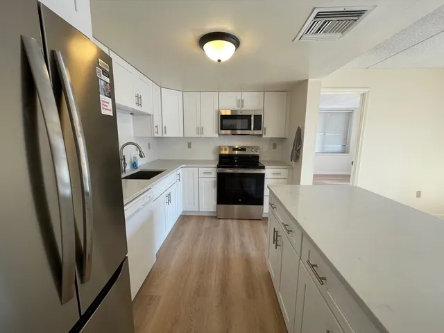 a kitchen with stainless steel appliances a refrigerator sink and cabinets