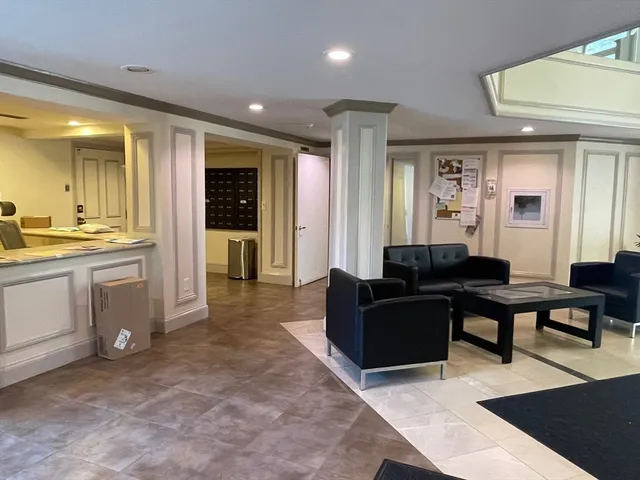 a living room with furniture a large window and kitchen view