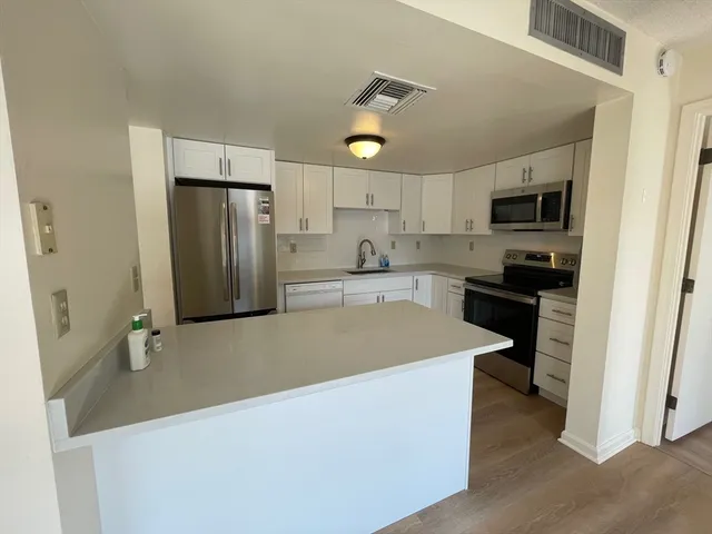 a kitchen with stainless steel appliances a refrigerator sink and stove