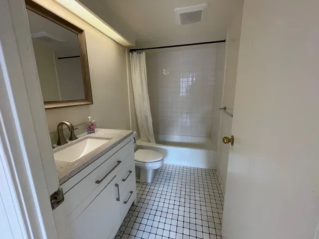 a bathroom with a granite countertop sink toilet and shower