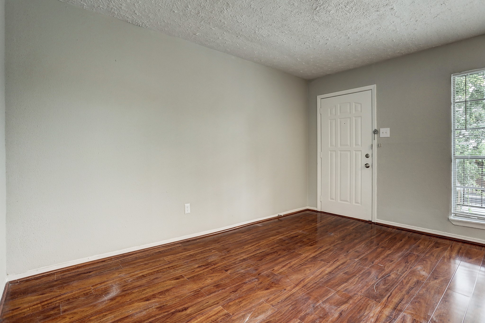 513 Ridge Street, Unit 21 Houston, TX 77009 - Photo 4 of 9 an empty room with wooden floor and windows