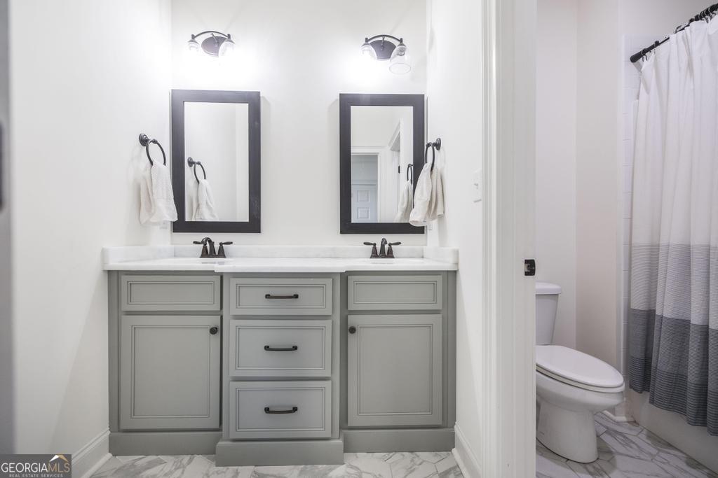 206 Bristleleaf Path Kathleen, GA 31047 - Photo 22 of 33 a bathroom with a double vanity sink a toilet and a mirror