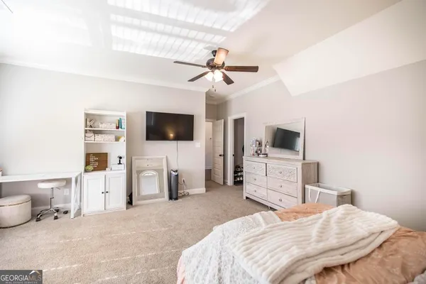 a bedroom with a bed flat screen tv and a chandelier