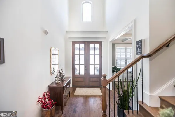 a hallway with wooden floor chandelier and entryway