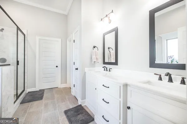 a bathroom with a double vanity sink mirror and shower