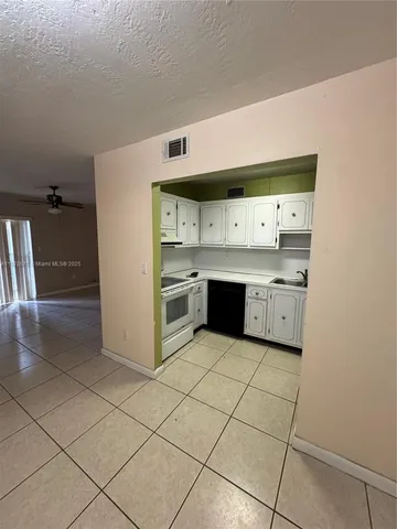 a kitchen with stainless steel appliances a stove top oven and cabinets