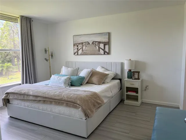 a bedroom with a bed a dresser next to a window