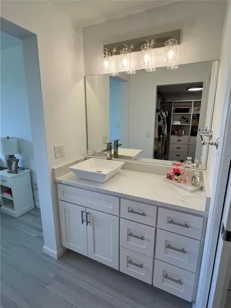 a bedroom with two beds and a large mirror next to a window