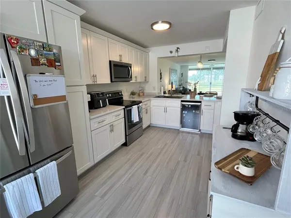 a kitchen with stainless steel appliances a stove top oven a sink a refrigerator and cabinets