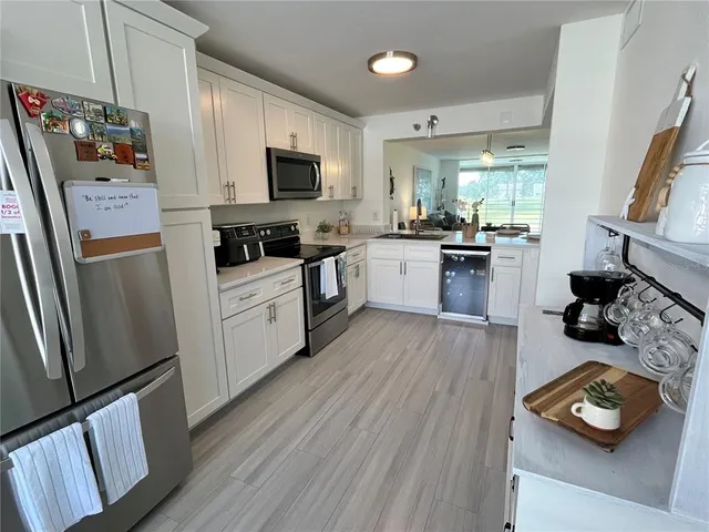 a kitchen with stainless steel appliances a stove top oven a sink a refrigerator and cabinets