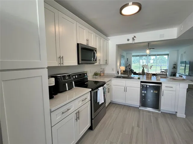 a kitchen with white cabinets and appliances