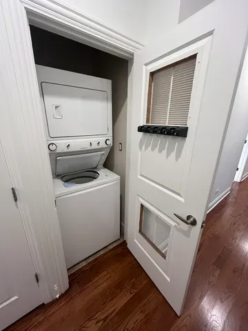 a utility room with wooden floor washer and dryer