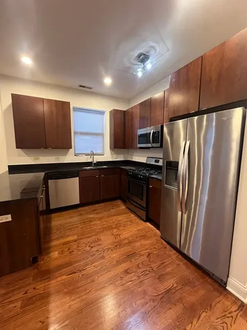 a kitchen with stainless steel appliances granite countertop a refrigerator sink and microwave