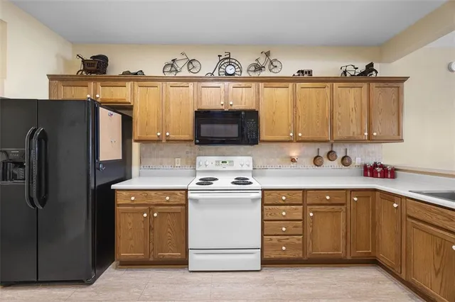 a kitchen with stainless steel appliances granite countertop a refrigerator stove and sink