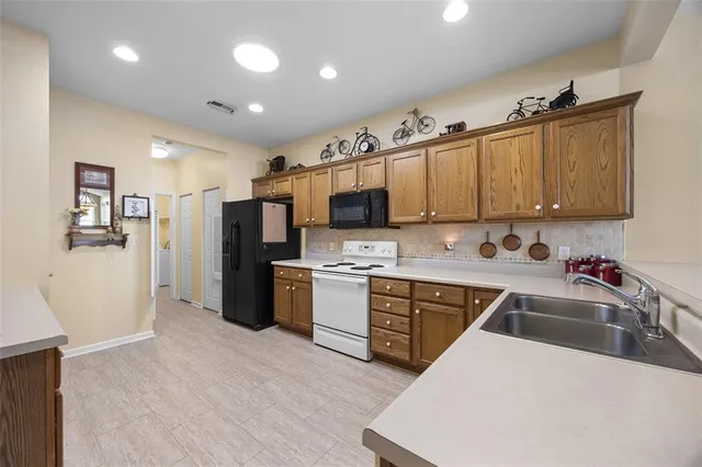 a kitchen with stainless steel appliances granite countertop a refrigerator sink and microwave
