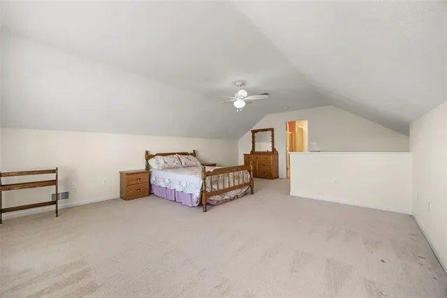 a spacious bedroom with a bed and a chandelier