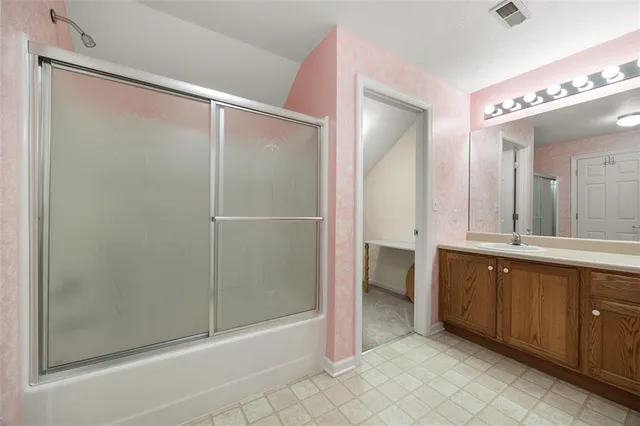 a spacious bathroom with a mirror a shower and a sink