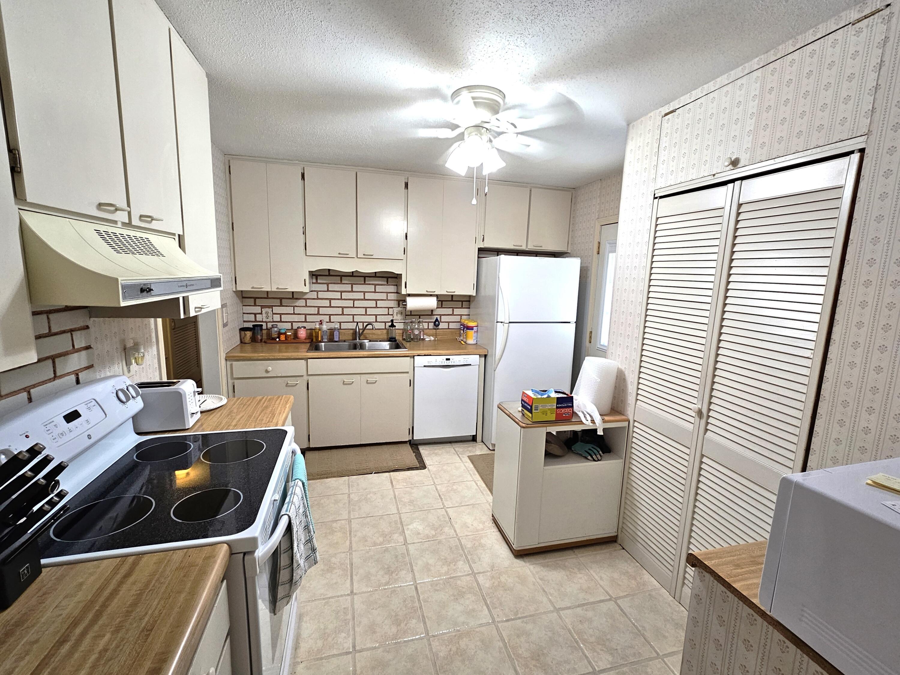 13 10th Street Shalimar, FL 32579 - Photo 7 of 17 a kitchen with a sink a stove a refrigerator and cabinets