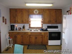 250 Tobacco Road Mill Spring, NC 28756 - Photo 5 of 7 a kitchen with granite countertop a stove a microwave a sink and a cabinets