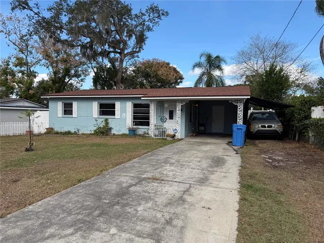front view of house with a yard and potted plants