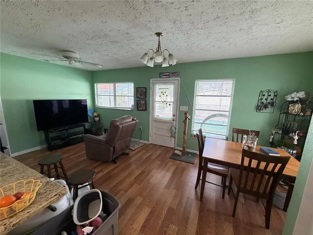 a living room with furniture a flat screen tv and a chandelier