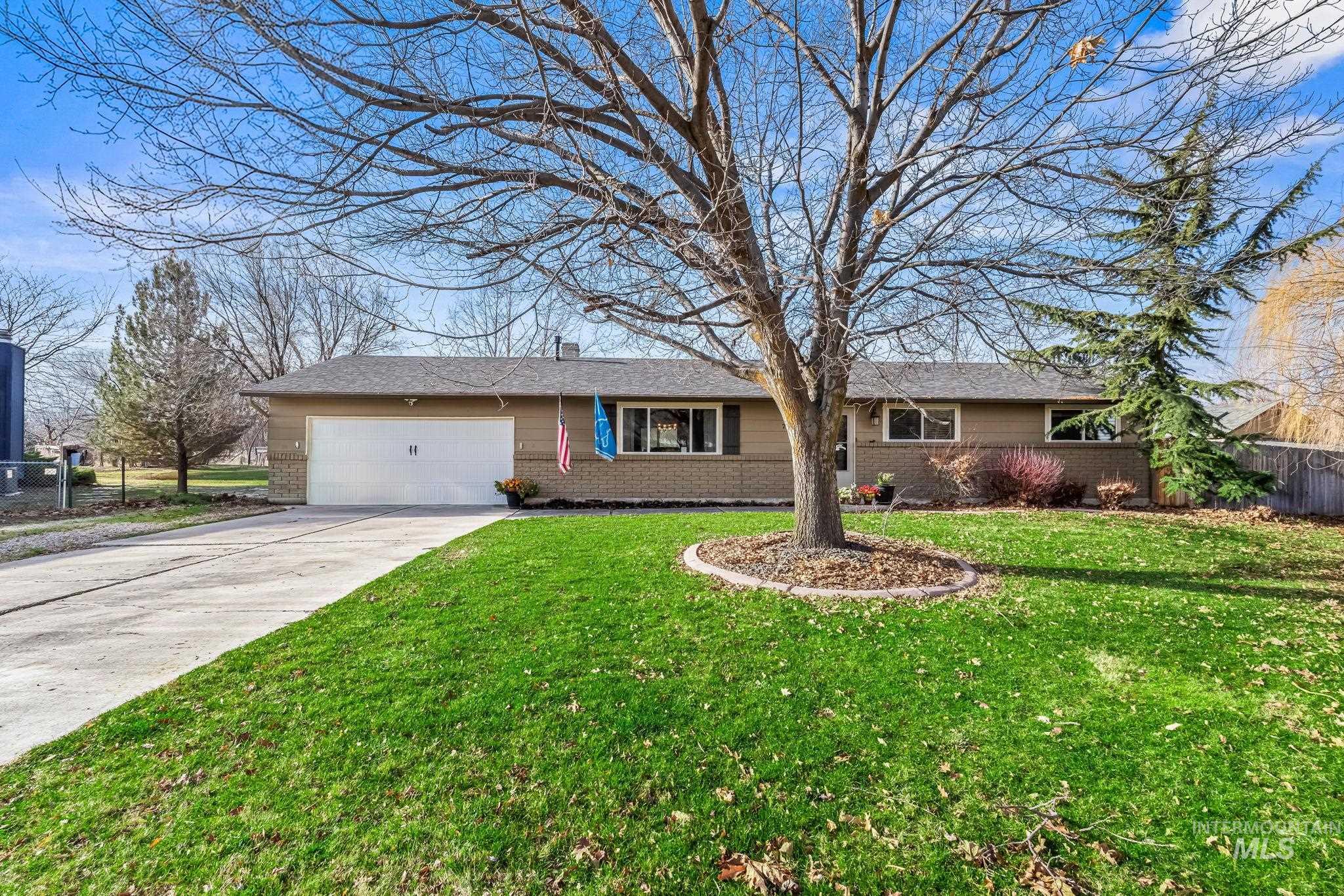 Single story home with concrete driveway, brick siding, a garage, and a chimney