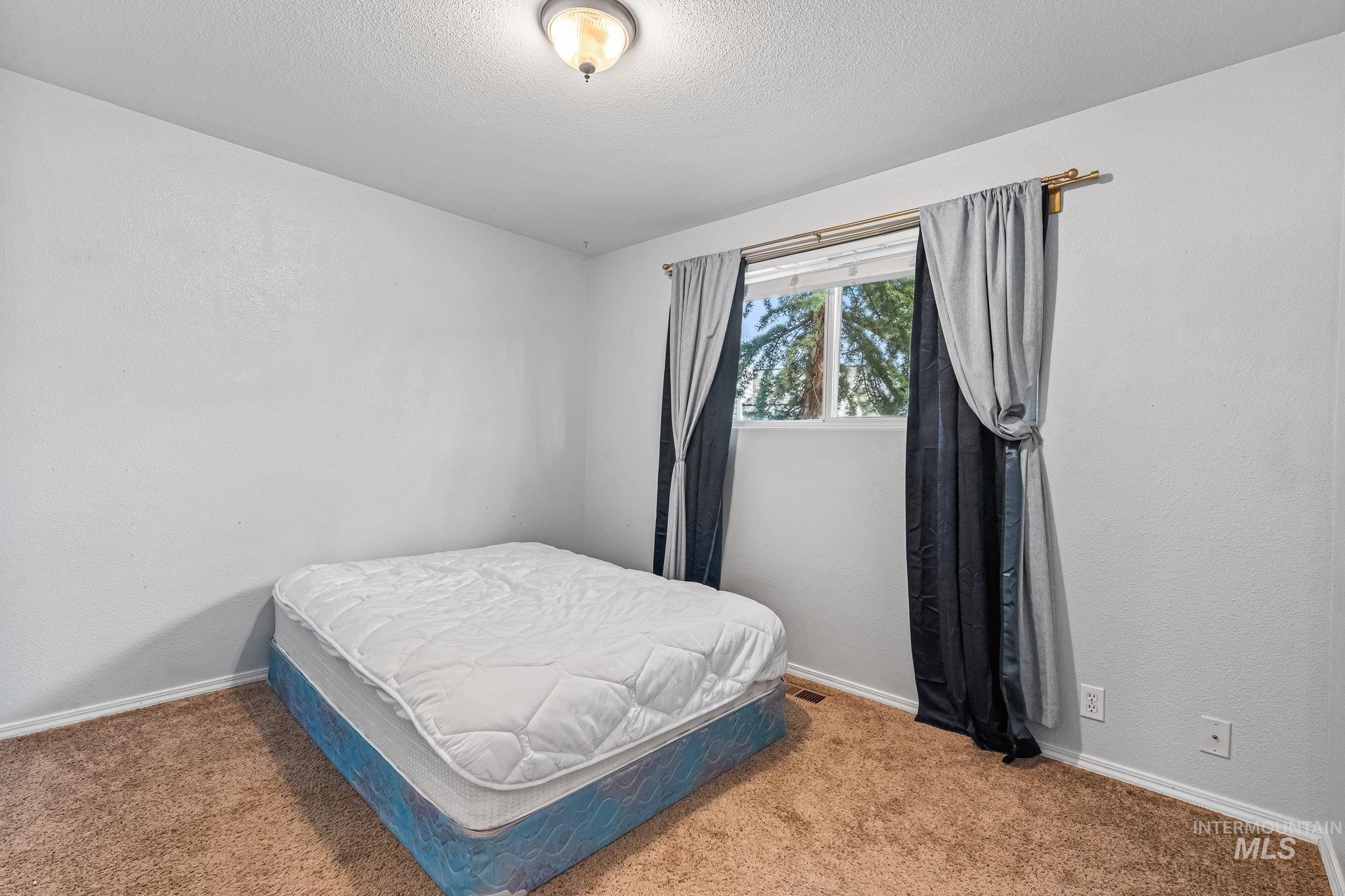 7650 West Colt Drive Boise, ID 83709 - Photo 15 of 30 Bedroom featuring carpet flooring and a textured ceiling