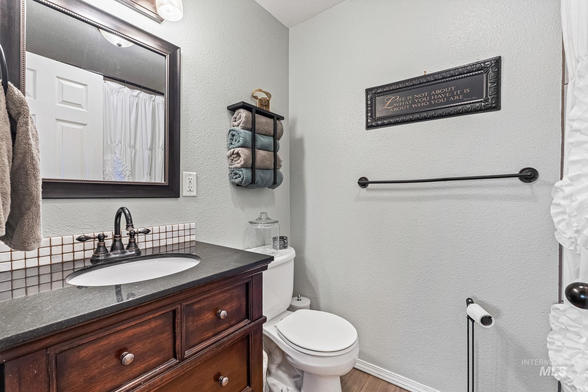 7650 West Colt Drive Boise, ID 83709 - Photo 16 of 30 Full bathroom with a shower with shower curtain, vanity, and a textured wall