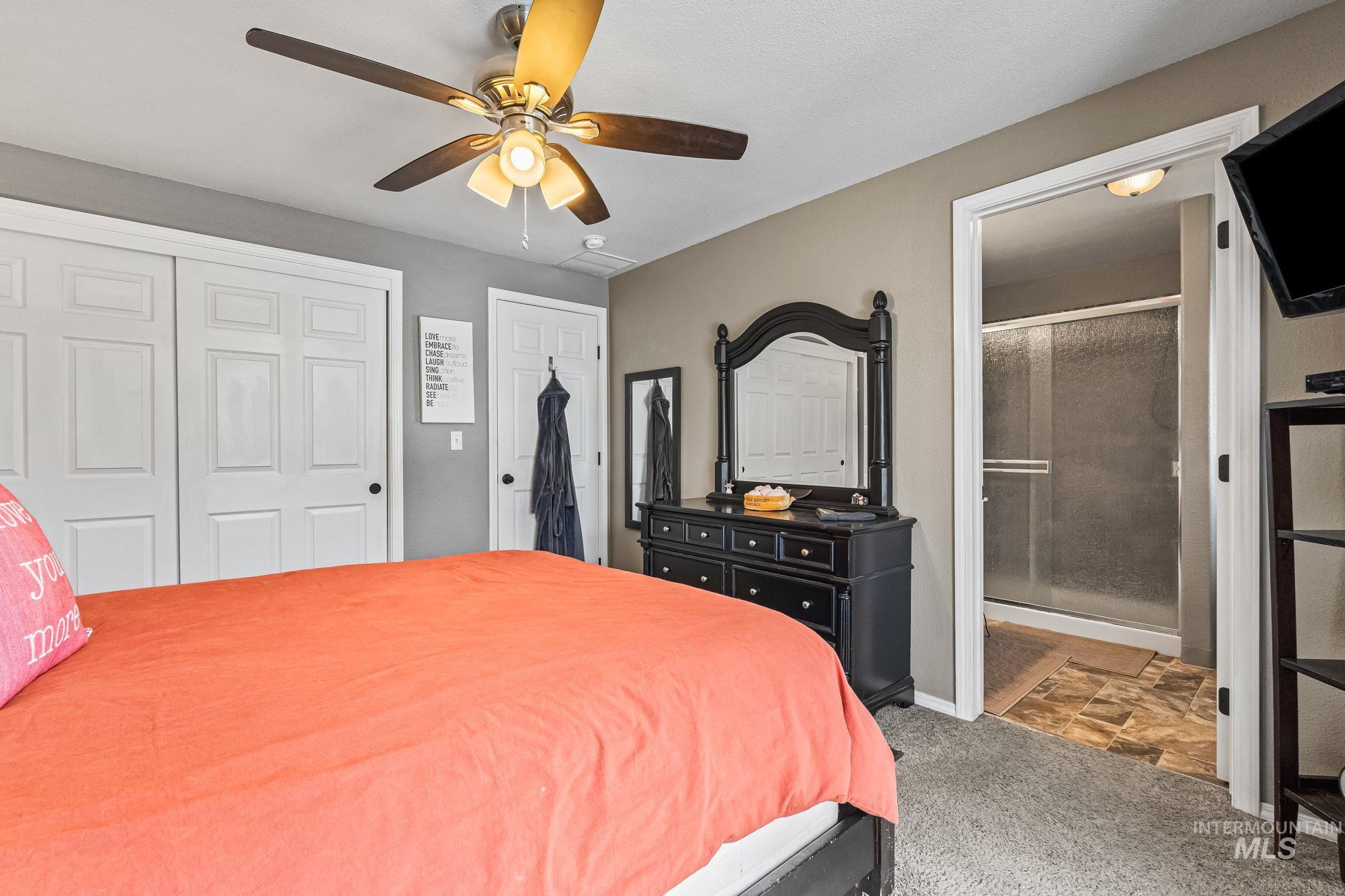 7650 West Colt Drive Boise, ID 83709 - Photo 18 of 30 Carpeted bedroom with a closet, ceiling fan, and connected bathroom