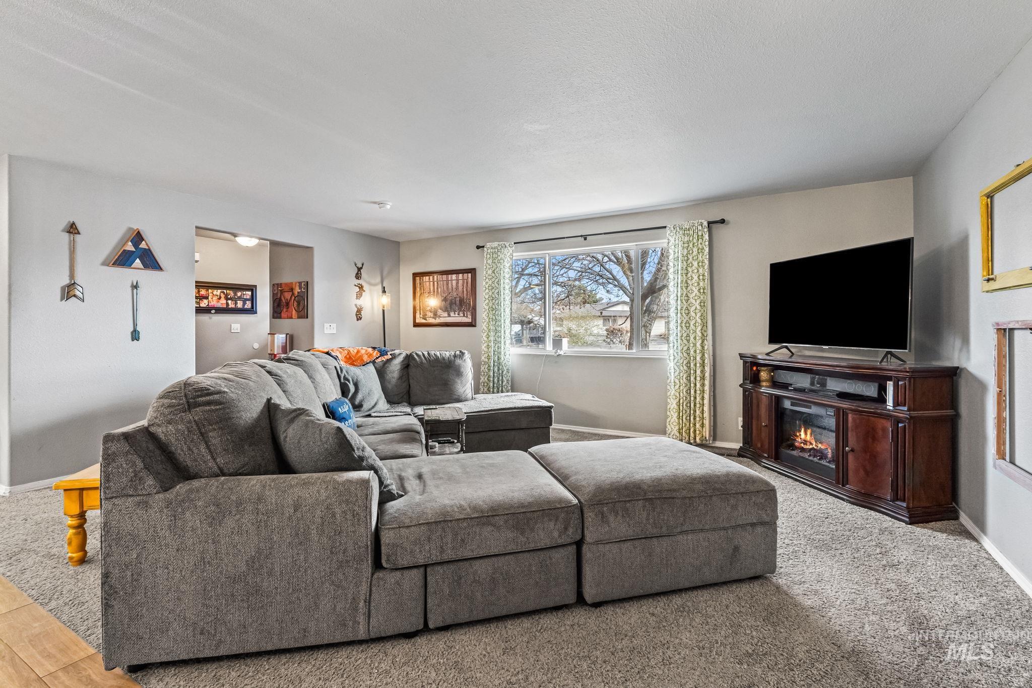 7650 West Colt Drive Boise, ID 83709 - Photo 7 of 30 Living room with baseboards and a glass covered fireplace