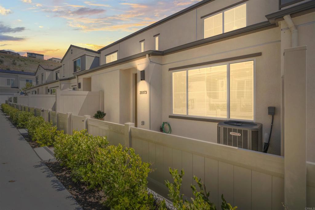 a view of a house with a large window and flower plants