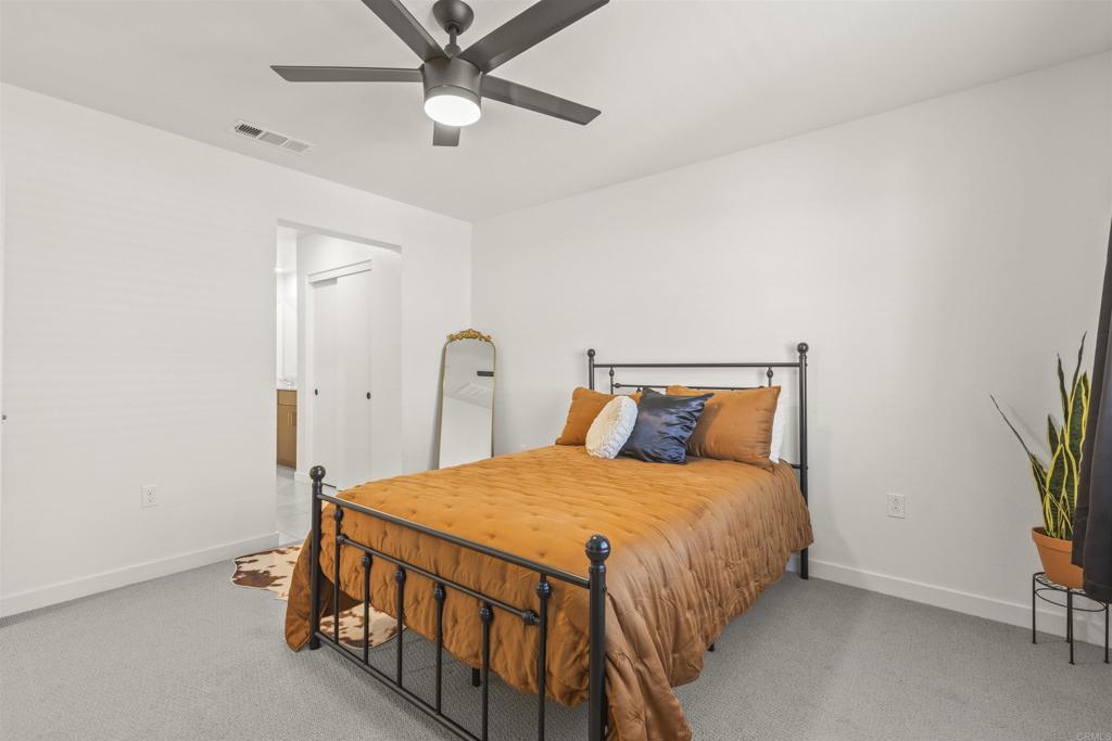 35173 Grove Trail Fallbrook, CA 92028 - Photo 16 of 30 a bedroom with a bed and a chandelier