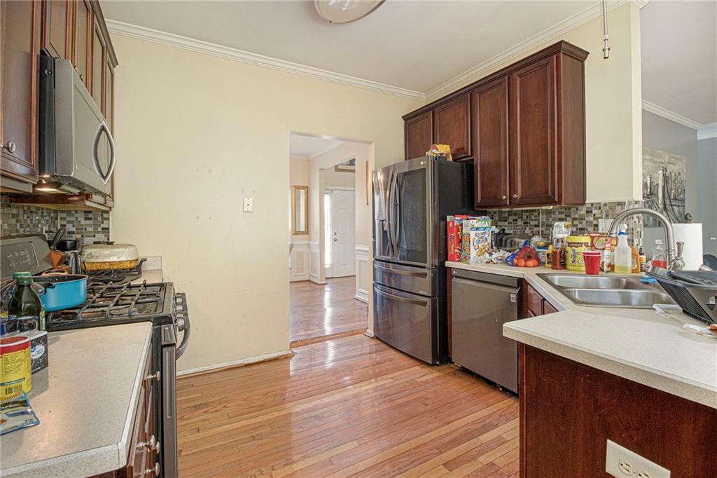 474 Boxelder Road Atlanta, GA 30349 - Photo 13 of 25 a kitchen with stainless steel appliances wooden floors and wooden cabinets