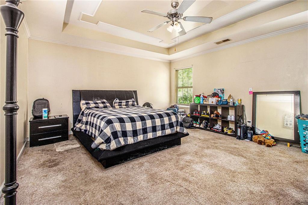 474 Boxelder Road Atlanta, GA 30349 - Photo 15 of 25 a bedroom with a bed and a chandelier