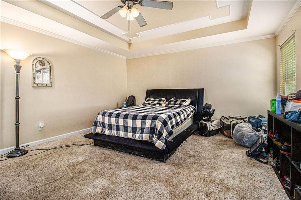 474 Boxelder Road Atlanta, GA 30349 - Photo 16 of 25 a bedroom with a bed and a chandelier