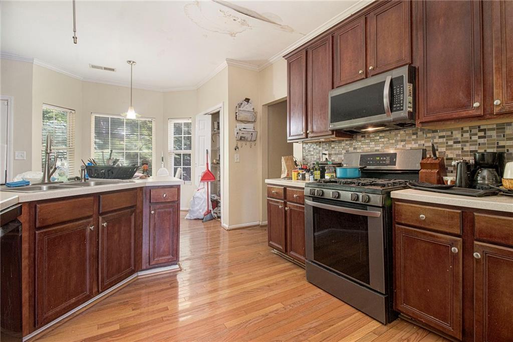 474 Boxelder Road Atlanta, GA 30349 - Photo 3 of 25 a kitchen with stainless steel appliances wooden cabinets and a stove top oven