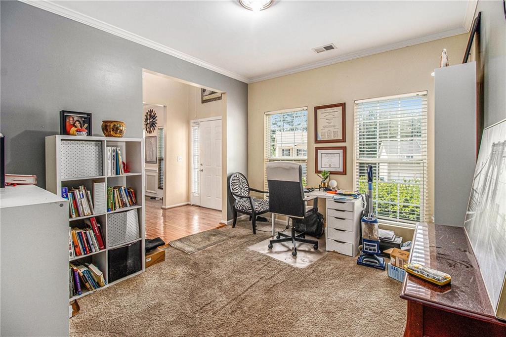 474 Boxelder Road Atlanta, GA 30349 - Photo 7 of 25 a view of a workspace with furniture and a bookshelf
