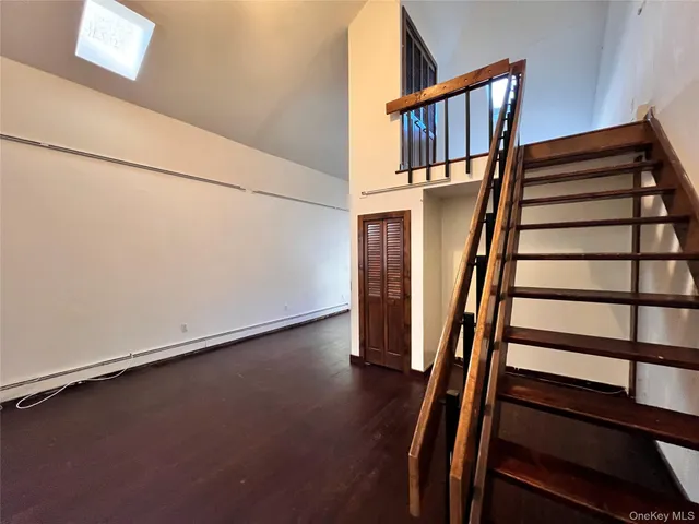 a view of staircase with wooden floor and white walls