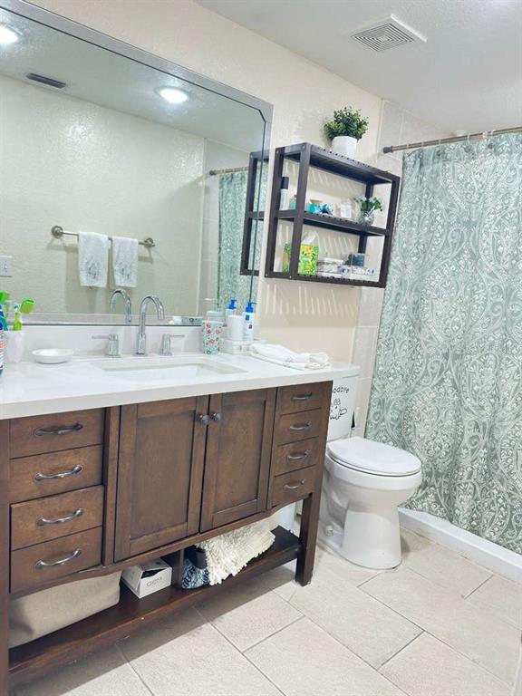 5100 Conroy Road, Unit 26 Orlando, FL 32811 - Photo 5 of 10 a bathroom with a sink mirror vanity and toilet
